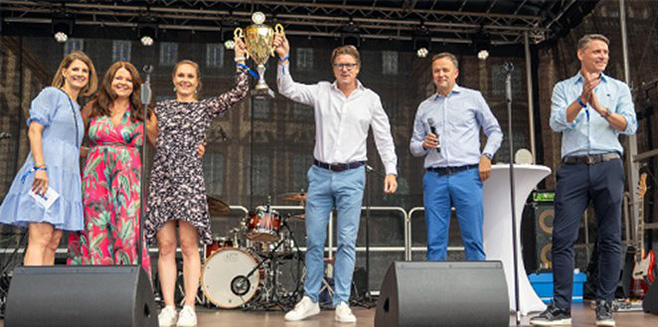 Board members present a large trophy on stage